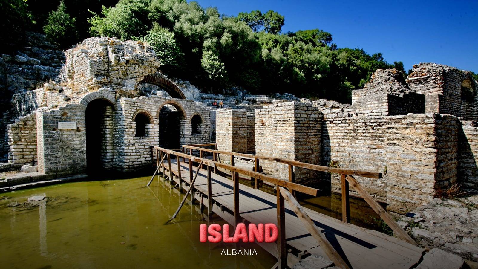 Ruins of the ancient city of Butrint with a wooden walkway over the water, near Ksamil, with the Party Island Albania logo